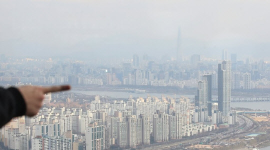 한 시민이 서울 도심 일대 아파트 밀집 지역을 가리키고 있다. <연합뉴스>